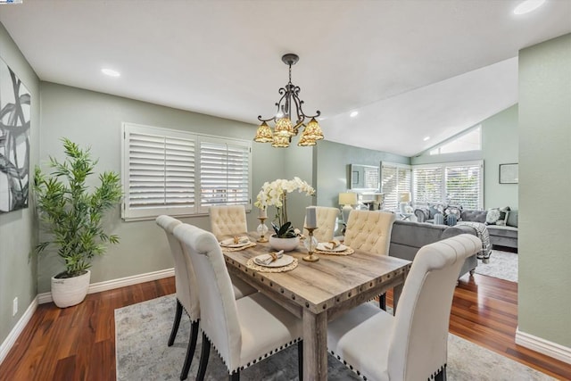 dining space with dark wood-type flooring, lofted ceiling, and an inviting chandelier