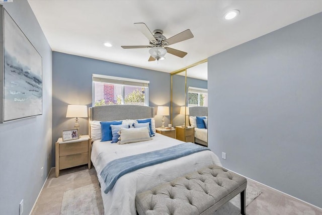 bedroom featuring ceiling fan, light colored carpet, and a closet