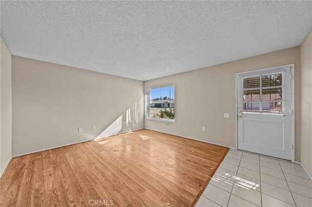 interior space featuring a textured ceiling and light tile patterned floors