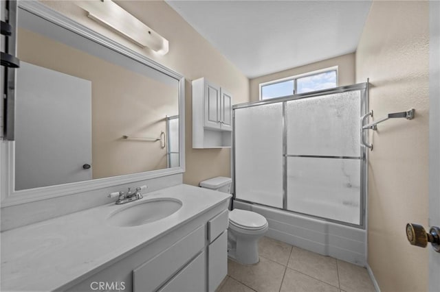 full bathroom featuring toilet, tile patterned floors, vanity, and enclosed tub / shower combo