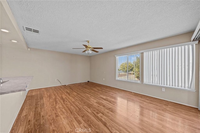 interior space featuring a textured ceiling, ceiling fan, and light hardwood / wood-style flooring