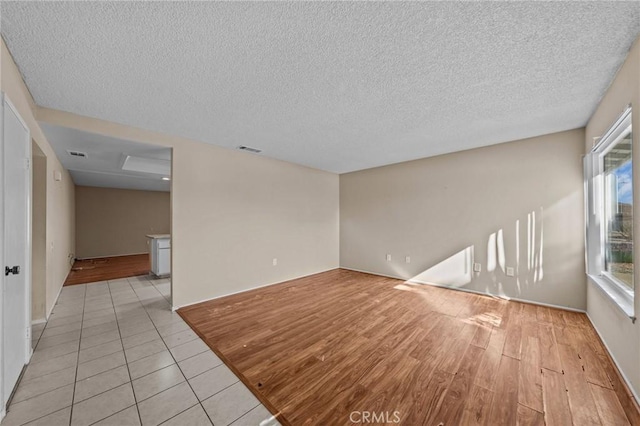 tiled spare room with a textured ceiling