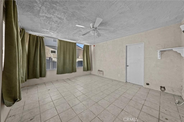 tiled empty room featuring ceiling fan