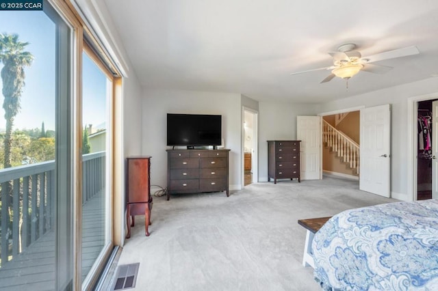 carpeted bedroom featuring ensuite bathroom, ceiling fan, and a spacious closet