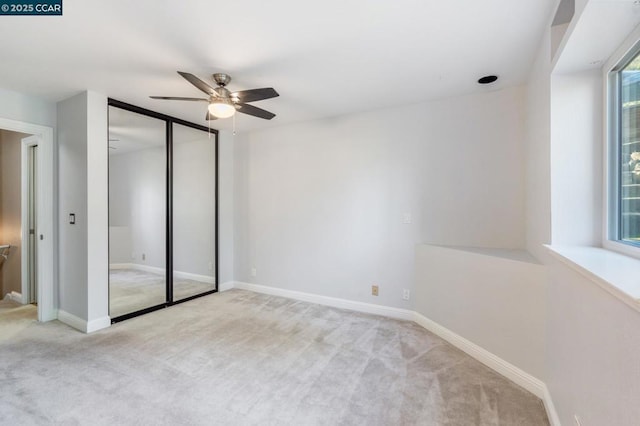 unfurnished bedroom featuring ceiling fan, light carpet, and multiple windows