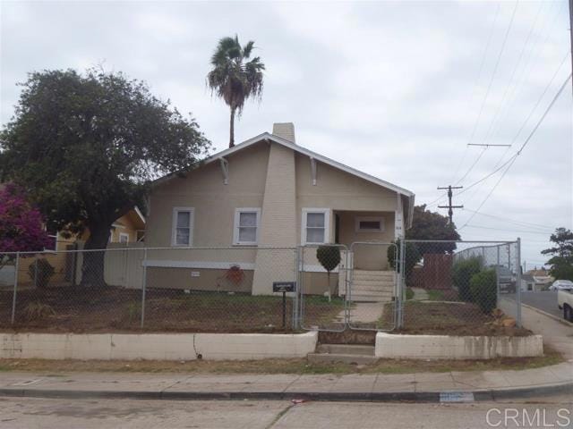 bungalow with a fenced front yard and a gate