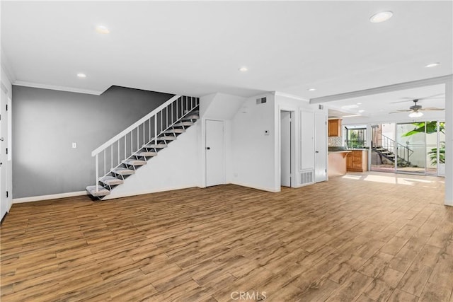 unfurnished living room featuring light wood-type flooring and ornamental molding