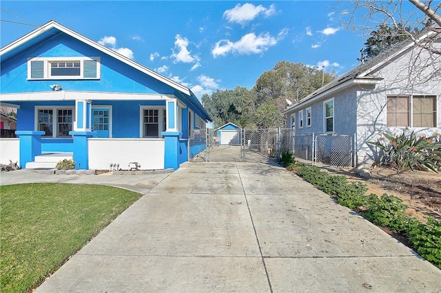 bungalow-style house featuring a porch, an outbuilding, a front lawn, and a garage