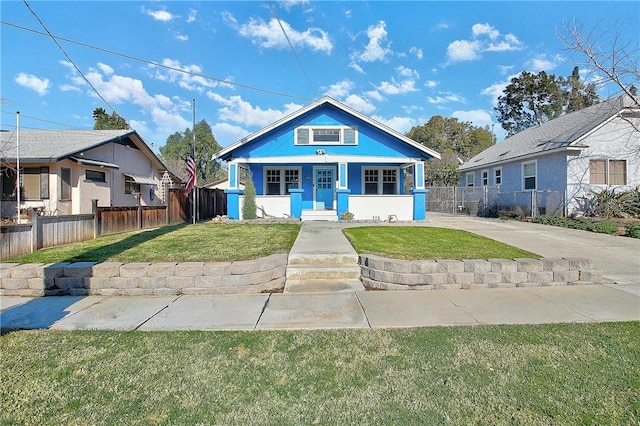 bungalow-style home with covered porch and a front lawn