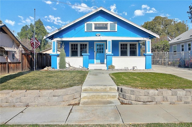 bungalow-style house featuring covered porch and a front lawn