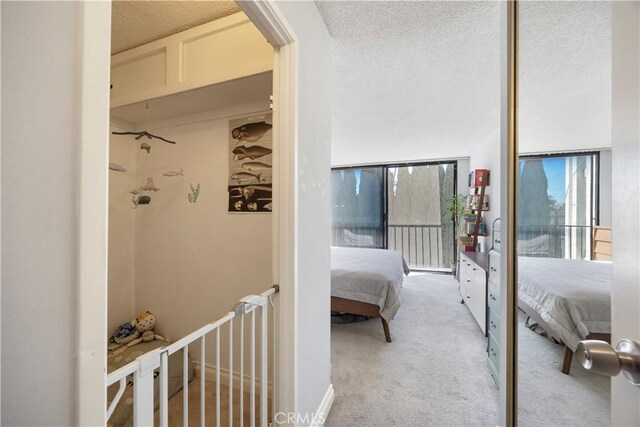 bedroom with light colored carpet and a textured ceiling