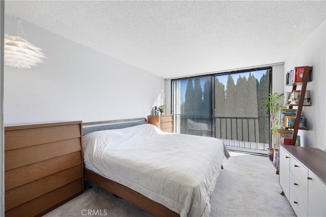 carpeted bedroom featuring a textured ceiling and floor to ceiling windows