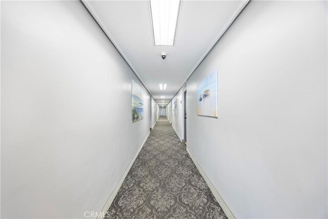 hallway featuring dark colored carpet