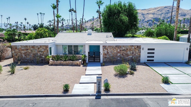 single story home featuring a garage and a mountain view