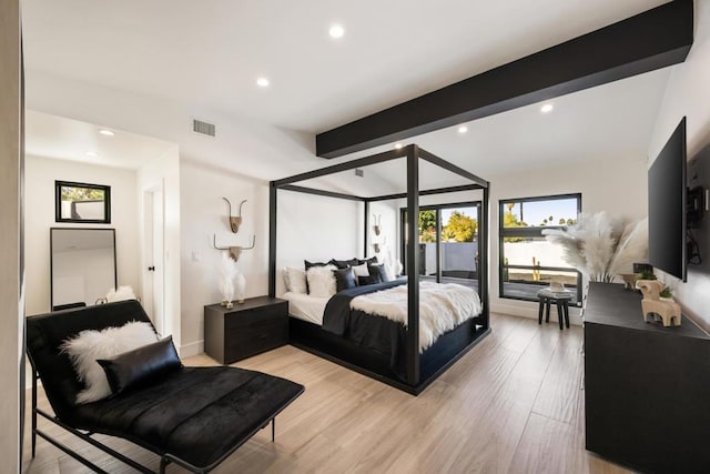 bedroom featuring beam ceiling and light hardwood / wood-style flooring