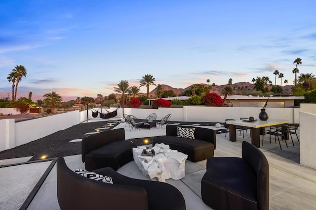 patio terrace at dusk with an outdoor living space with a fire pit