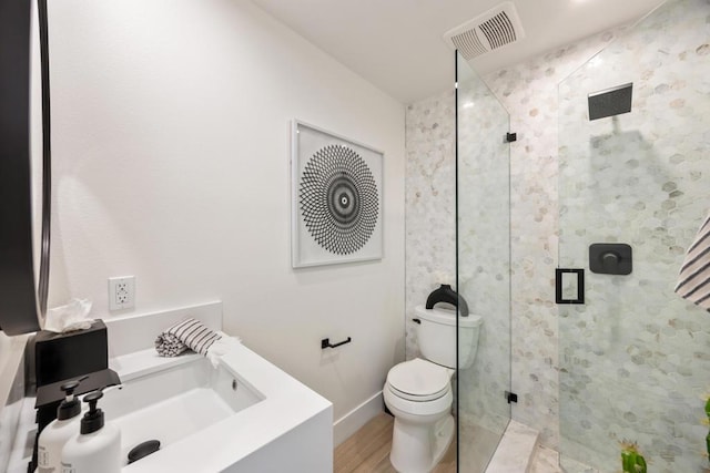 bathroom featuring toilet, sink, a shower with door, and hardwood / wood-style flooring