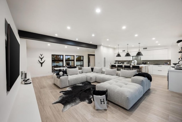 living room featuring light hardwood / wood-style floors and beam ceiling