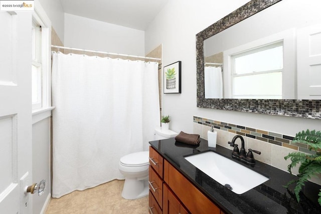 bathroom featuring toilet, vanity, and decorative backsplash