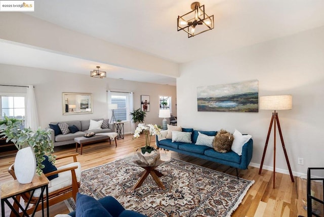 living room featuring light wood-type flooring and a notable chandelier