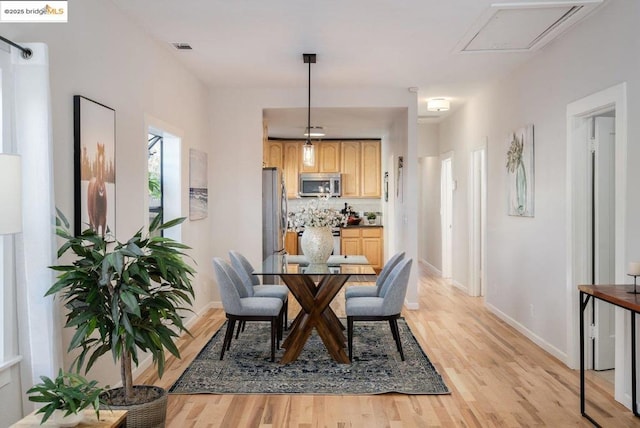 dining space with light hardwood / wood-style floors