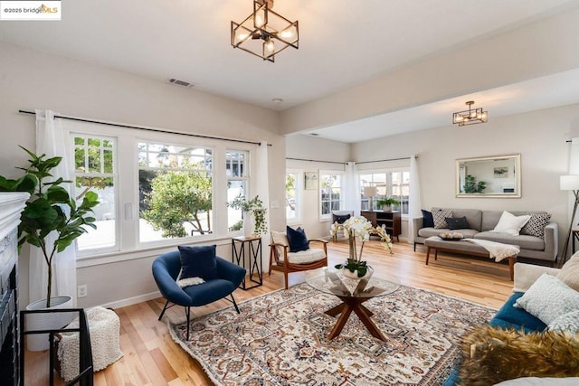 living room featuring light wood-type flooring and a notable chandelier