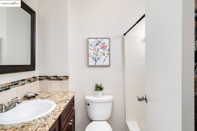 bathroom with toilet, a shower, backsplash, and vanity