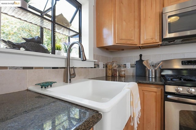 kitchen with appliances with stainless steel finishes, tasteful backsplash, and sink