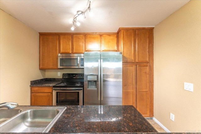 kitchen with sink, rail lighting, and appliances with stainless steel finishes