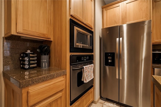 kitchen with stainless steel appliances, light brown cabinetry, light tile patterned floors, and decorative backsplash