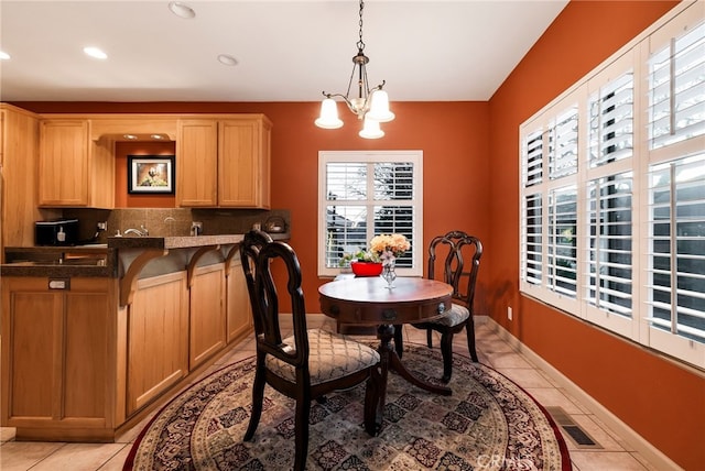 tiled dining room featuring a chandelier