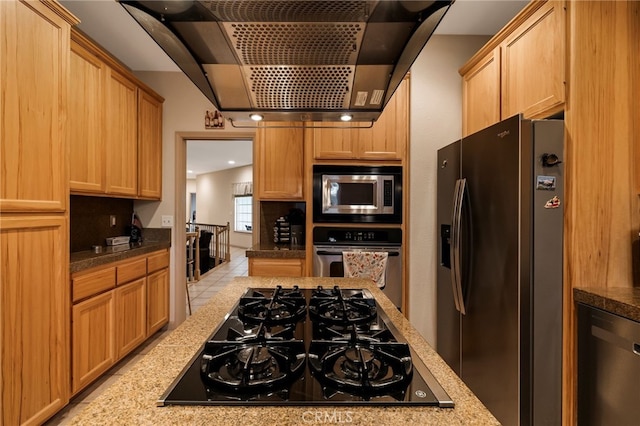 kitchen with black appliances, wall chimney range hood, and light stone countertops