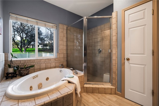 bathroom featuring shower with separate bathtub and wood-type flooring