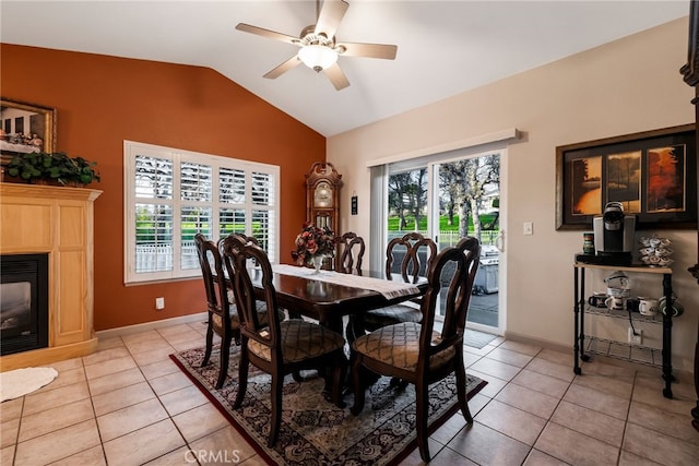 dining space featuring light tile patterned flooring, ceiling fan, and vaulted ceiling