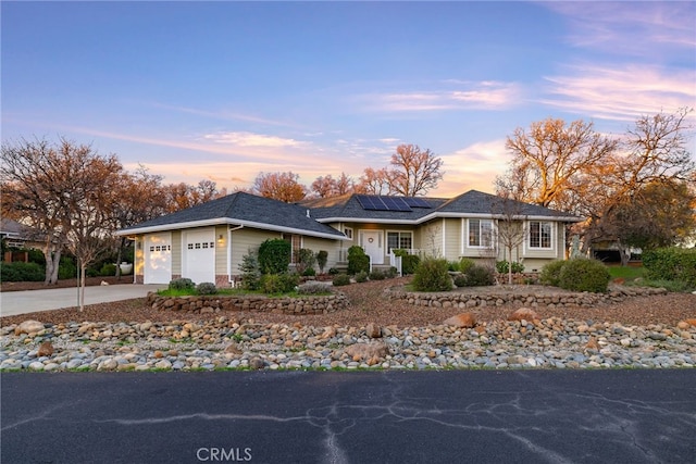 single story home with solar panels and a garage