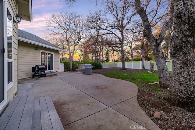 patio terrace at dusk featuring area for grilling