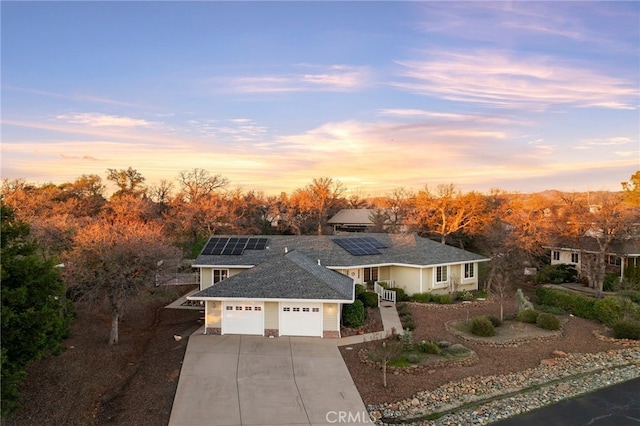 view of front of property featuring a garage and solar panels