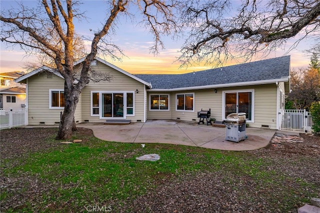 back house at dusk featuring a patio area