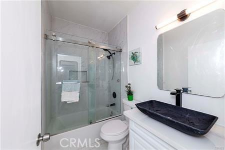 full bathroom featuring enclosed tub / shower combo, vanity, and toilet