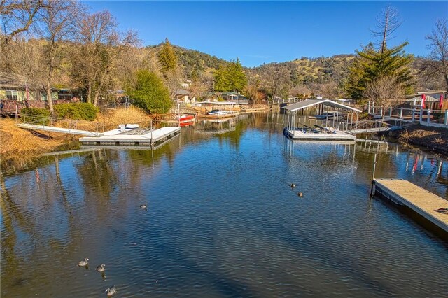 property view of water featuring a boat dock and a mountain view