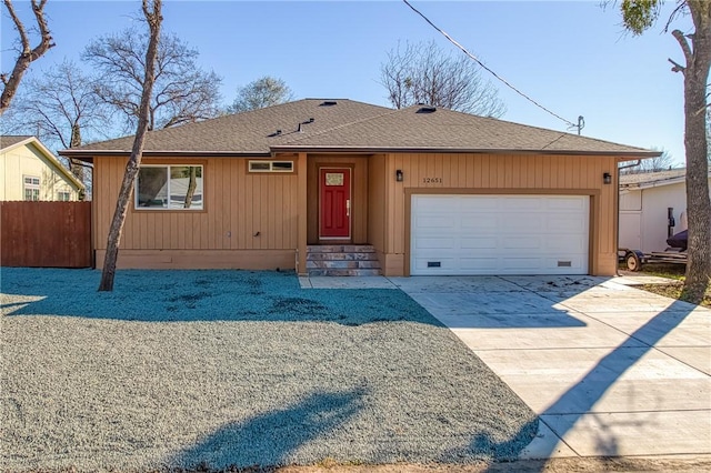 ranch-style house with a garage, a shingled roof, fence, and concrete driveway