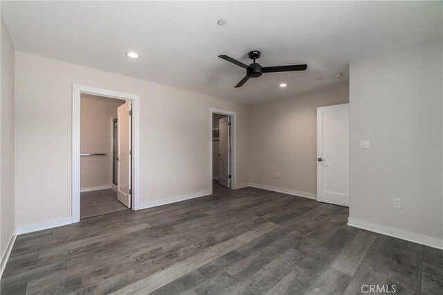 unfurnished bedroom featuring a spacious closet, ceiling fan, a closet, dark hardwood / wood-style floors, and ensuite bath