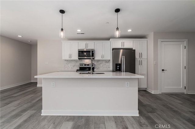 kitchen featuring a sink, white cabinets, light countertops, appliances with stainless steel finishes, and tasteful backsplash