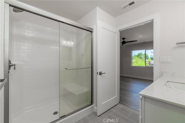 bathroom with vanity, ceiling fan, and walk in shower