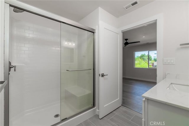 bathroom featuring visible vents, ceiling fan, a shower stall, and vanity