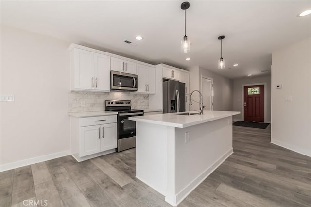 kitchen featuring white cabinetry, sink, hanging light fixtures, a kitchen island with sink, and stainless steel appliances