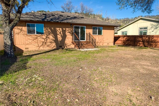 rear view of property featuring a lawn