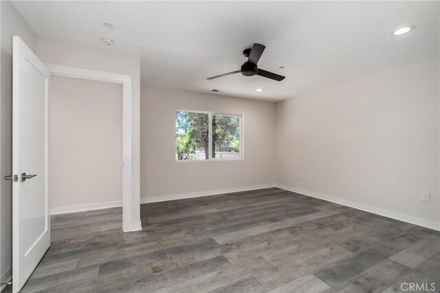 spare room with dark hardwood / wood-style flooring and ceiling fan