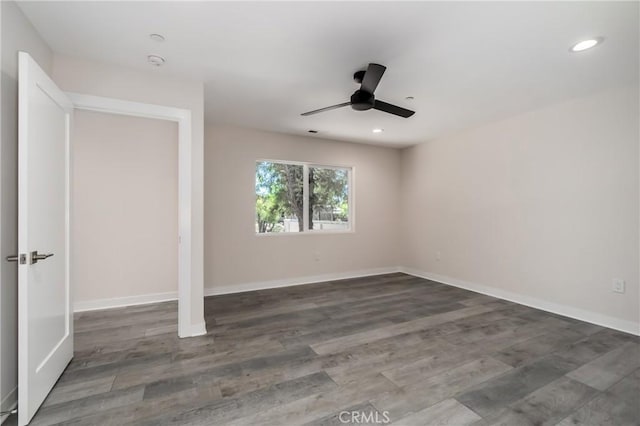 empty room with ceiling fan and dark hardwood / wood-style flooring