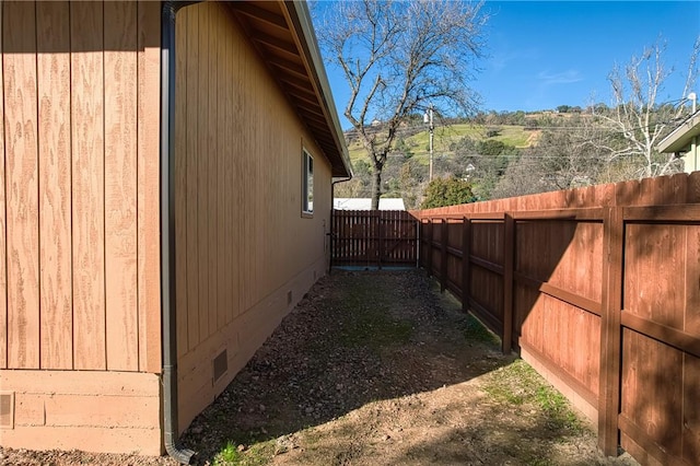 view of home's exterior with crawl space and fence